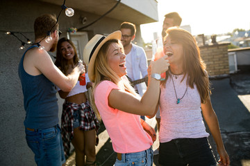 Group of young people having fun at a summertime party, at sunset