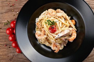 Spagetti with shrimp on a black plate (Fettuccine)