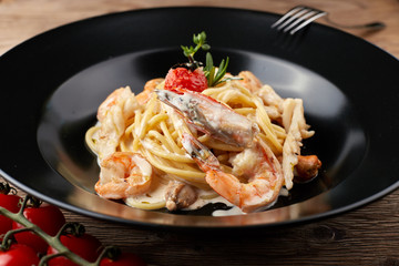 Spagetti with shrimp on a black plate (Fettuccine)