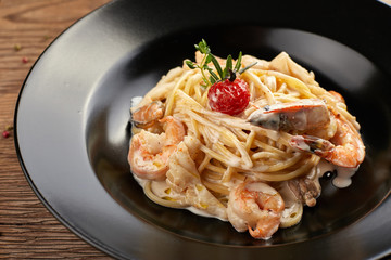 Spagetti with shrimp on a black plate (Fettuccine)