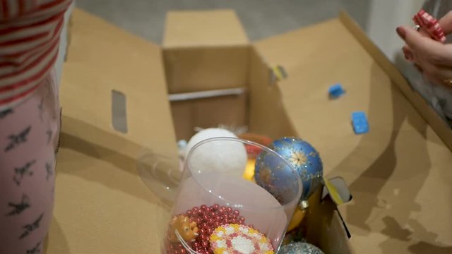 Happy family decorating a Christmas tree with boubles in the living-room