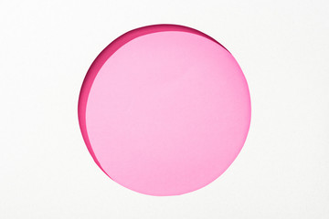 Obraz premium cut out round hole in white paper on pink colorful background