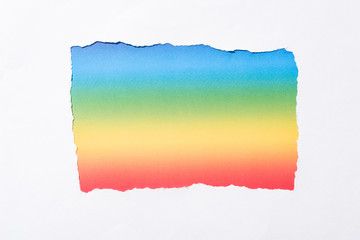 rainbow colorful background in white torn paper hole