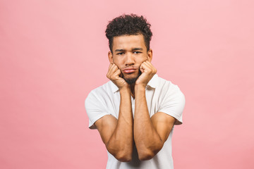 Serious afro american man thinking isolated over pink background.