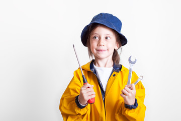 Kid girl with wrenches, repair tools holds thumb up.Repair auto mechanic concept. 