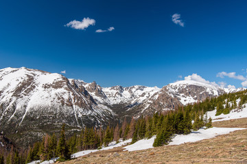 Rocky Mountain National Park low angle landscape of snow-covered mountain peaks and some clouds on a sunny day