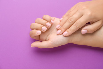 Female hands with beautiful manicure on color background