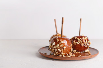 Plate with tasty candy apples on light table