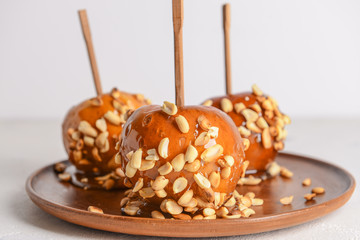 Plate with tasty candy apples on light table, closeup