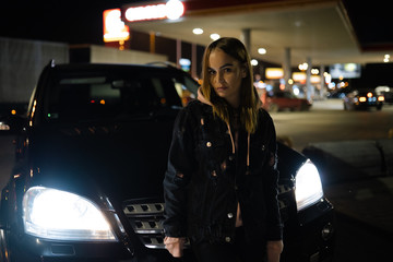 Fototapeta na wymiar Blonde woman portrait standing at night in front of expensive car - Luxury and Fashion