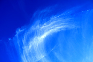 Delicate white cloud in perfect blue sky.