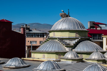 Turkey, Middle East: a stork with its cubs and the nest on the dome of a mosque in the city of Igdir, capital of Igdır Province in the Eastern Anatolia Region of Turkey near the Armenian border 