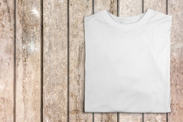 White T-shirt on wooden background top view