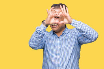 Middle age arab business man over isolated background Doing heart shape with hand and fingers smiling looking through sign