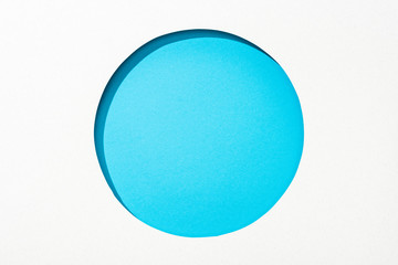 cut out round hole in white paper on blue bright colorful background
