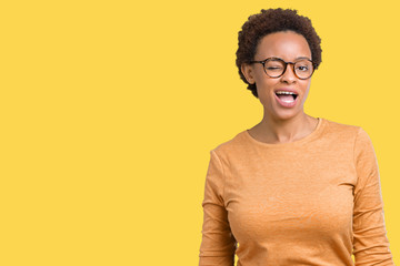 Young beautiful african american woman wearing glasses over isolated background winking looking at...