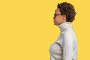 Young beautiful african american woman wearing glasses over isolated background looking to side, relax profile pose with natural face with confident smile.
