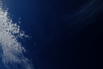 Bright white clouds in polarized deep blue sky,  wide angle perspective, cirrus and cirrus stratus clouds.