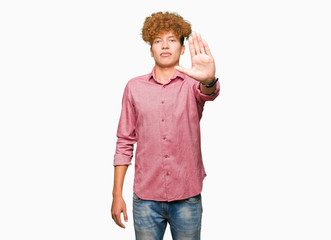 Young handsome business man with afro hair doing stop sing with palm of the hand. Warning...