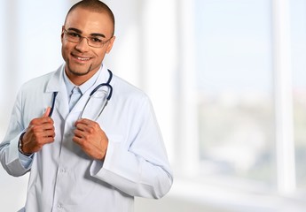 Male doctor with stethoscope on blurred hospital background