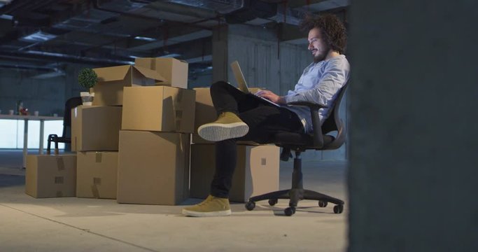 Handsome businessman is looking out the window and smiling while standing in 