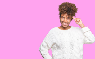 Beautiful young african american woman wearing winter sweater over isolated background Smiling pointing to head with one finger, great idea or thought, good memory
