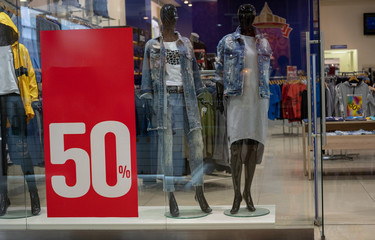 Season sale, black friday and shopping concept. Sale signs on stands in shop. Sale sign 50% percent...