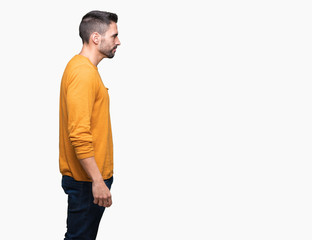 Fototapeta premium Young handsome man over isolated background looking to side, relax profile pose with natural face with confident smile.