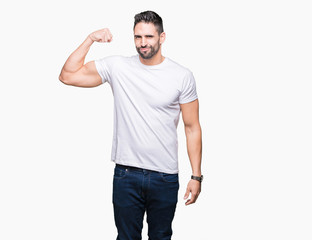 Handsome man wearing white t-shirt over white isolated background Strong person showing arm muscle,...