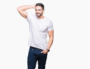 Fototapeta premium Handsome man wearing white t-shirt over white isolated background Smiling confident touching hair with hand up gesture, posing attractive