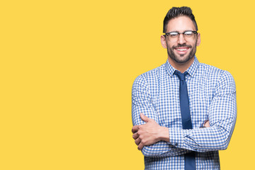 Young business man wearing glasses over isolated background happy face smiling with crossed arms...