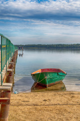 Before I&rsquo;m back on board. A wooden fishing boat moored on the shore of a small lake.