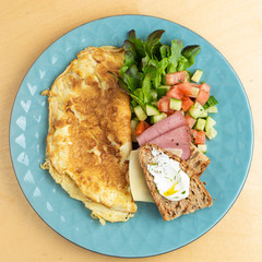 Continental breakfast: fluffy omelette with salad, cream cheese, cheddar, ham and toasts