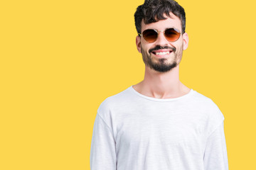 Young handsome man wearing sunglasses over isolated background with a happy and cool smile on face. Lucky person.