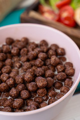 Close up of full bowl of crunchy chocolate balls with milk