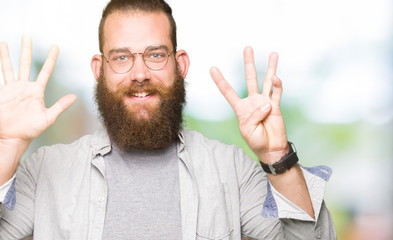 Young blond man wearing glasses showing and pointing up with fingers number nine while smiling confident and happy.