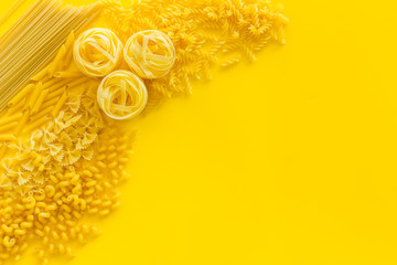 Italian pasta on yellow table background top view mock up