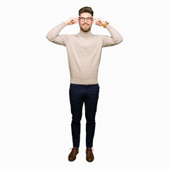 Young handsome business man wearing glasses Smiling pointing to head with both hands finger, great idea or thought, good memory