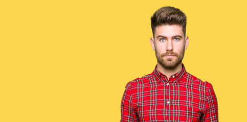 Young handsome man with serious expression on face. Simple and natural looking at the camera.