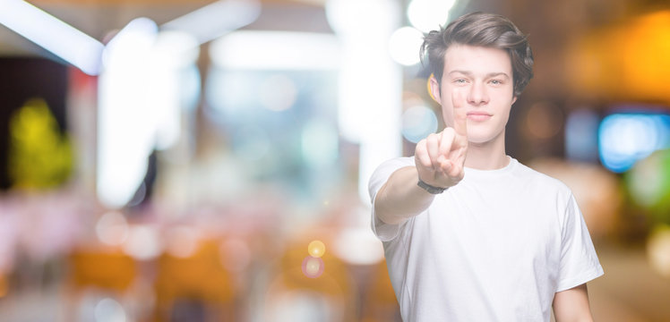 Young handsome man wearing casual white t-shirt over isolated background Pointing with finger up and angry expression