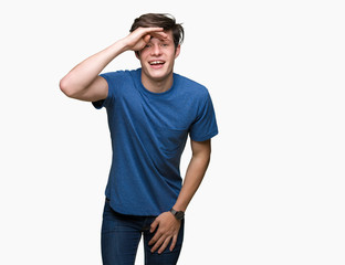 Fototapeta premium Young handsome man wearing blue t-shirt over isolated background very happy and smiling looking far away with hand over head. Searching concept.
