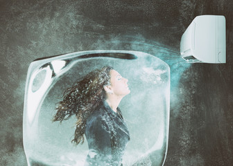 Woman frozen in an ice cube under the air jet of an air conditioner