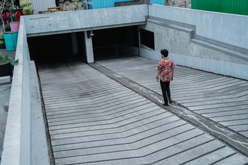 portrait young asian man from behind entrace the building