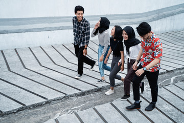 Obraz premium Five young friends walking posing on the way together when hanging out