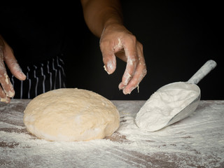 Cook is creating a dough to make bread.
