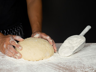 Cook is creating a dough to make bread.