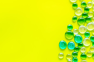 Pattern from colored glass stones on yellow background top view mockup