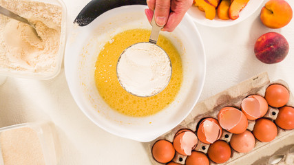 Baking Cake with Dough Recipe Ingredients and Fresh Peaches. Top View, White Background