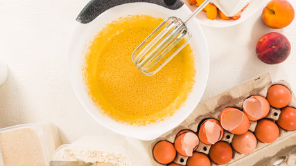 Baking Cake with Dough Recipe Ingredients and Fresh Peaches. Top View, White Background