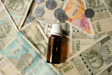 Empty Medicine bottle on Indian currency notes. Isolated focus. Medicine bill concept 